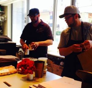 L-R: Brick 29 and On the Fly owner and chef Dustan Bristol and manager Doug Stinson cranking out sandwiches, soups, salads and desserts for the lunch hour crowd. Photo by Jeanne Huff